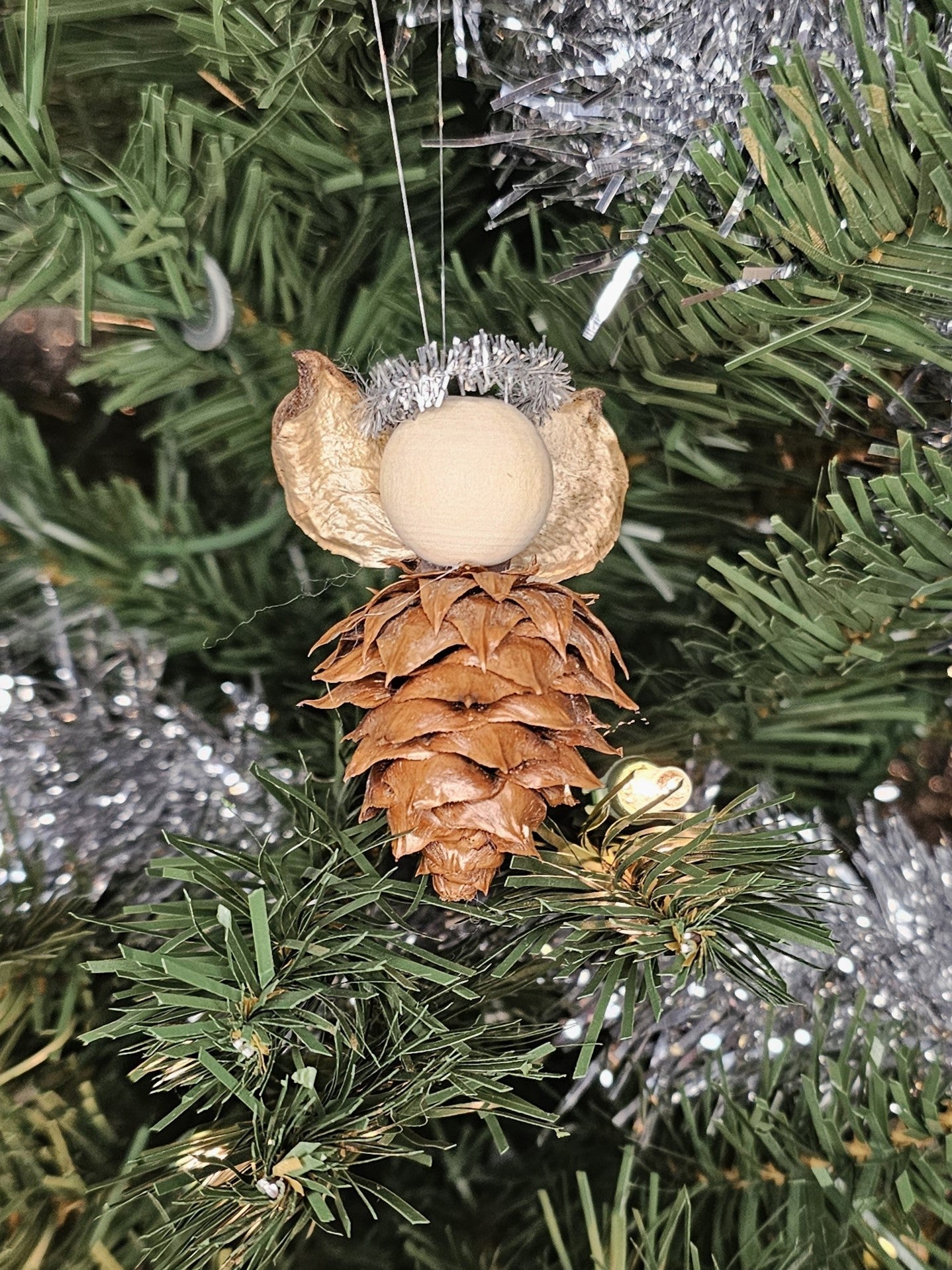 Silver handmade China Fir Tree Cone Angel Christmas Ornament on a Christmas Tree