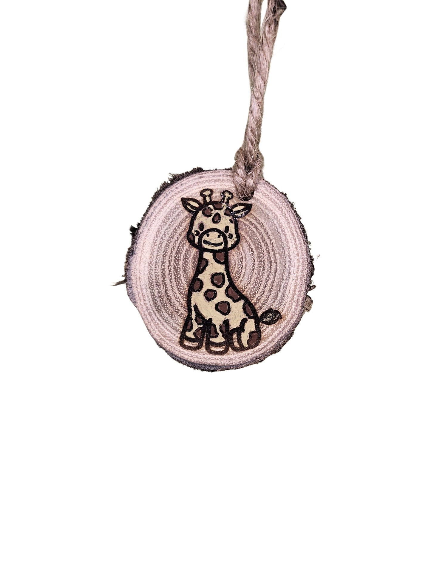 A wood burned Christmas tree ornament depicting a giraffe with a laser engraved hand drawn design, suspended by a twine string.
