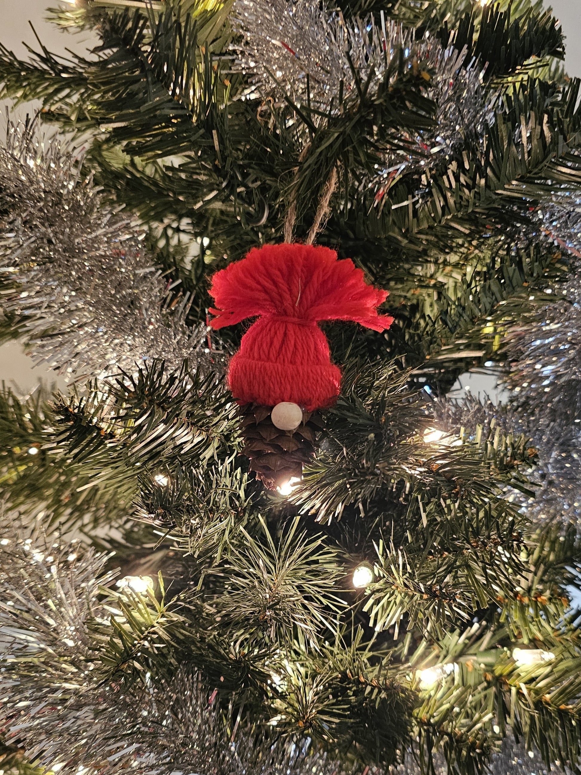 Handmade China Fir Tree Cone Gnome Christmas Ornament with a red hat on a Christmas tree