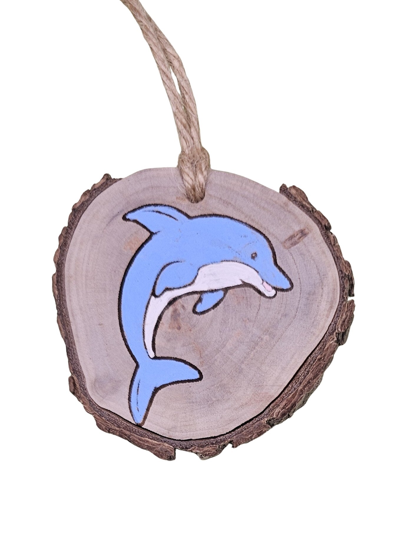 A wood burned Christmas tree ornament depicting a dolphin with a laser engraved hand drawn design, suspended by a twine string.