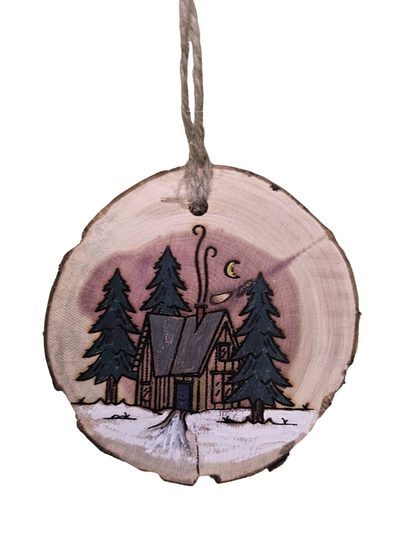 Wooden ornament with a cabin and trees design on a white background