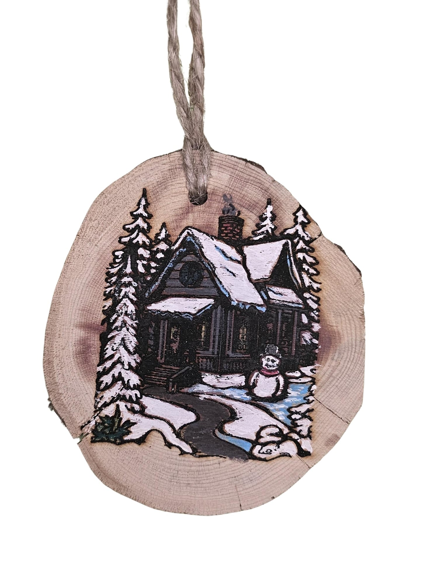 Wooden ornament with a winter scene of a house and snowman on a white background